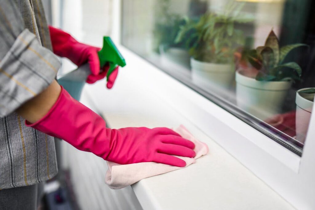 Someone cleaning a counter top with a spray and cloth