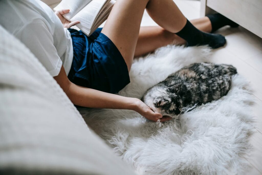 A lady relaxing on a white carpet and reading a book